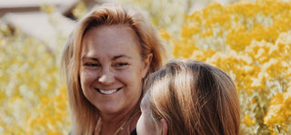 Woman in her 40s smiling in a field of flowers